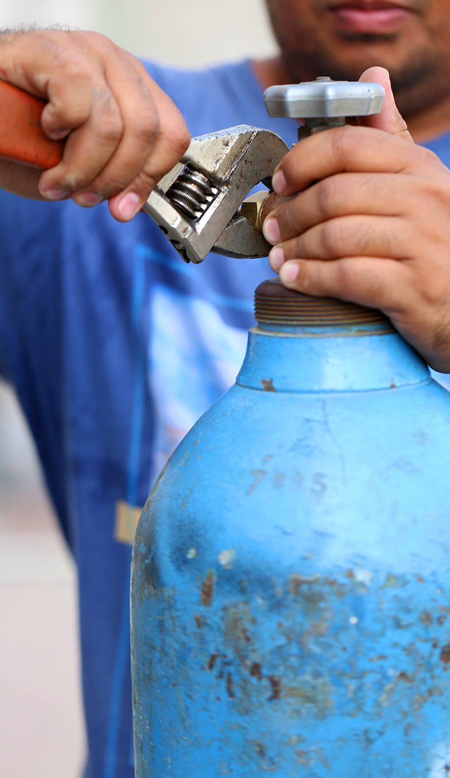 Mann führt Reparatur an einer Gasflasche durch